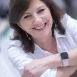 Femme souriante, chemise blanche, regard chaleureux
