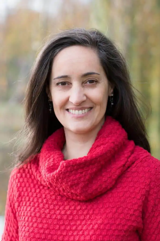 Portrait souriant d'une femme portant un pull rouge.